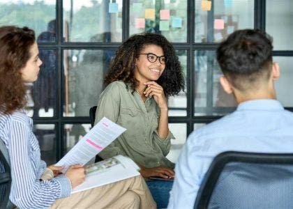 Three people sat in a meeting