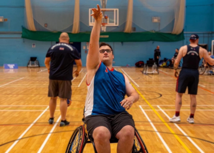 Matt sat in his wheelchair shooting a basketball in a gym