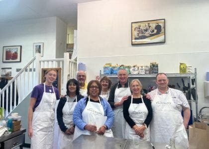 A group of CSSC members in cooking aprons at Vaughan's Kitchen Cookery School