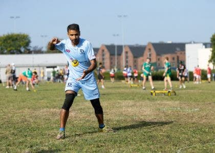 Faisal about to throw a ball on a field with other players in the background